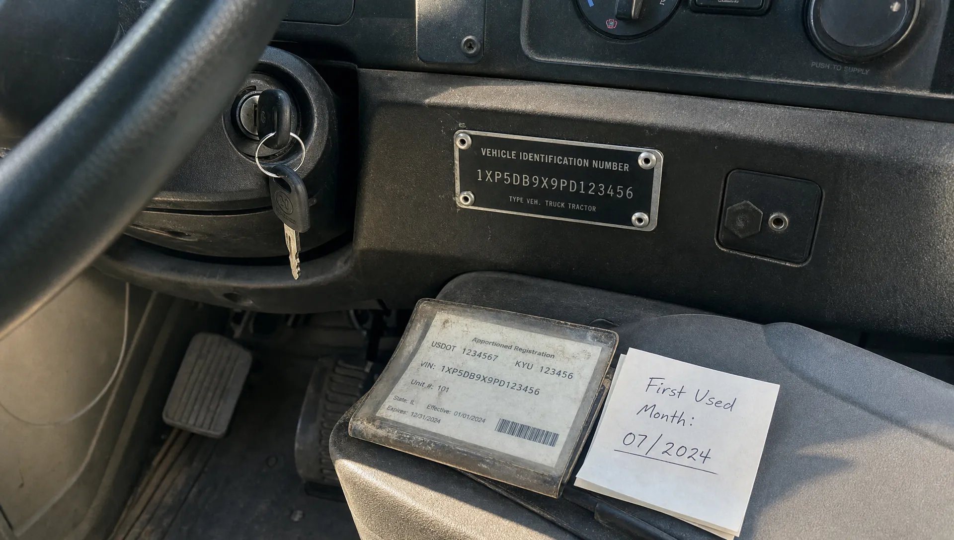 A truck cab VIN plate sits beside a key, registration sleeve and note for Form 2290 verification.